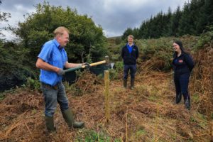 A farmer in the Caha catchment is fencing off his river, with the help of two Teagasc advisors who are looking on.
