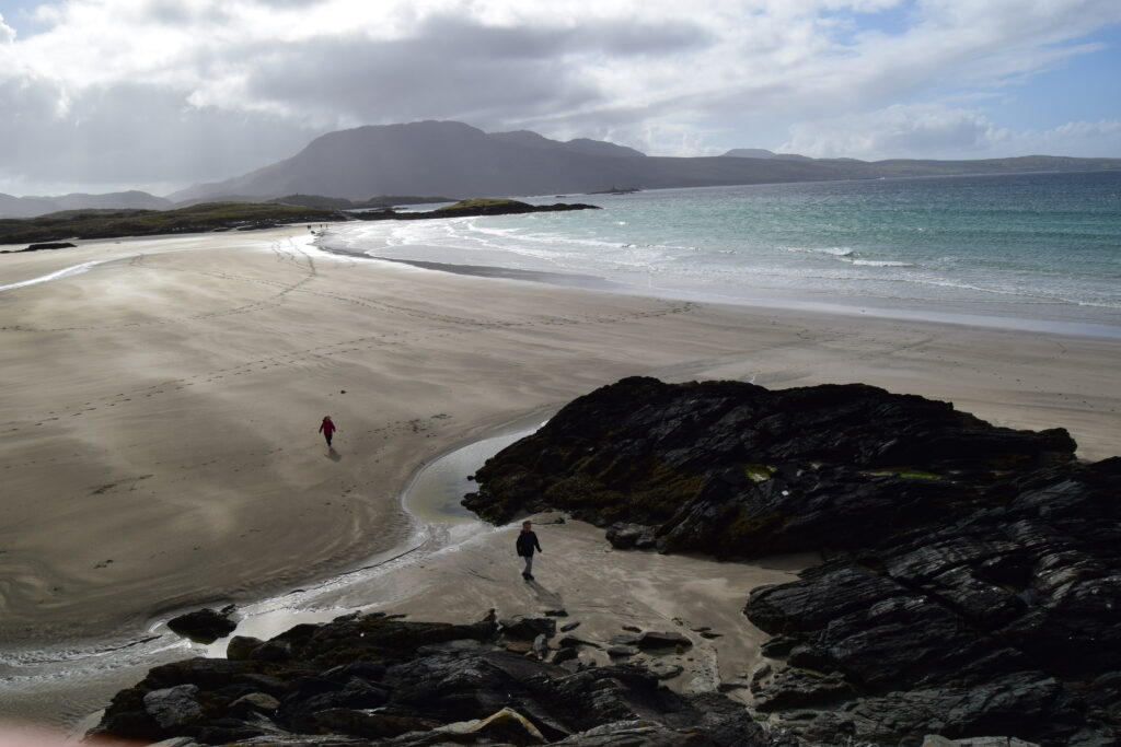 A late evening on a beach with mountains in the background